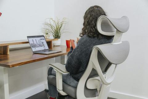 Frau arbeitet am Laptop an einem Schreibtisch