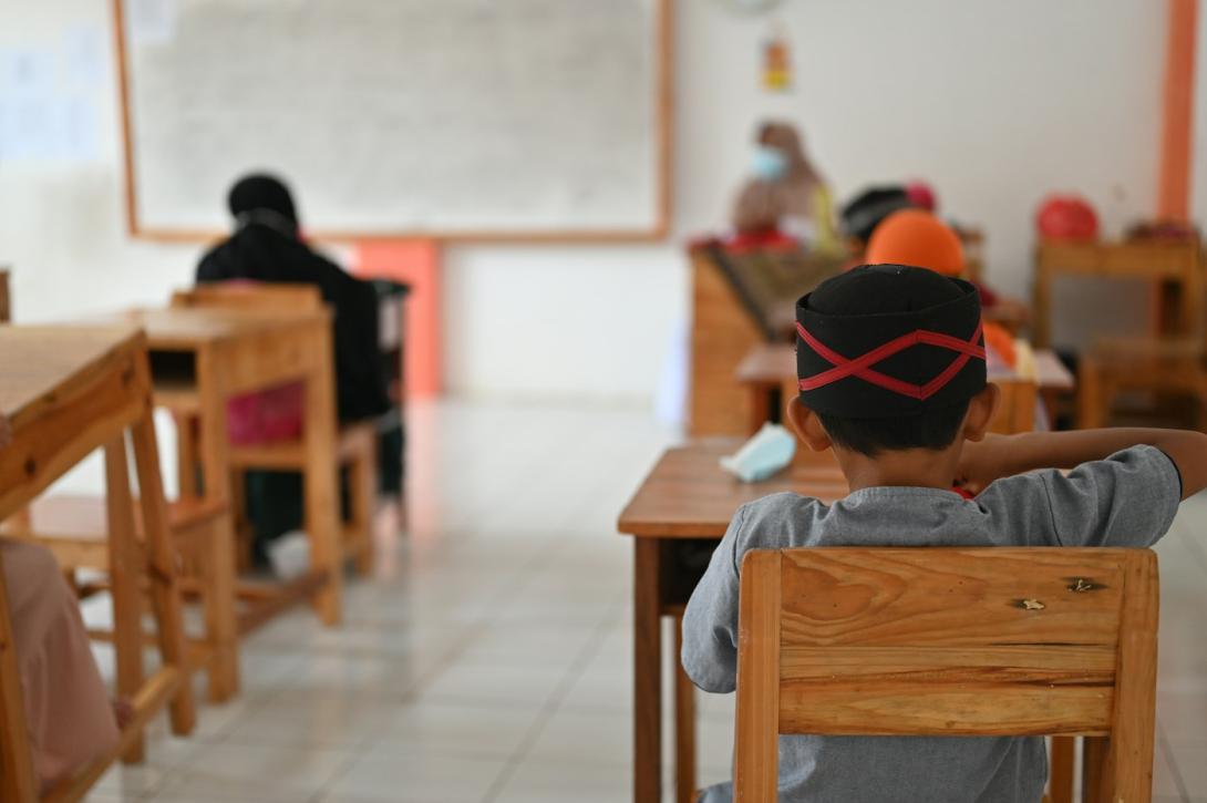Kind sitzt an einem Tisch im Klassenzimmer