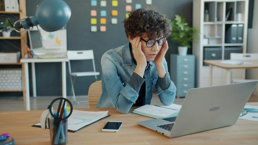 Gestresste Person am Laptop im Büro