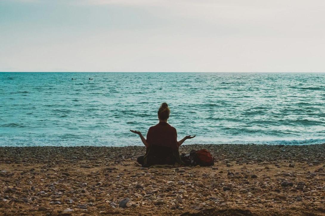 Person macht Yoga am Meer