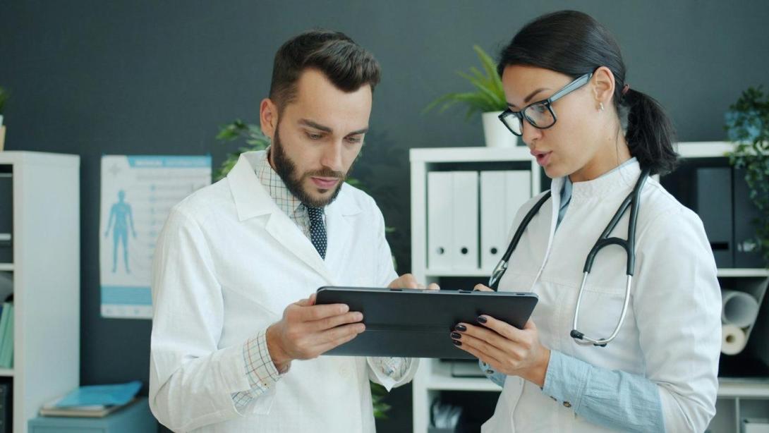 Zwei Ärztinnen und Ärzte betrachten gemeinsam ein Tablet
