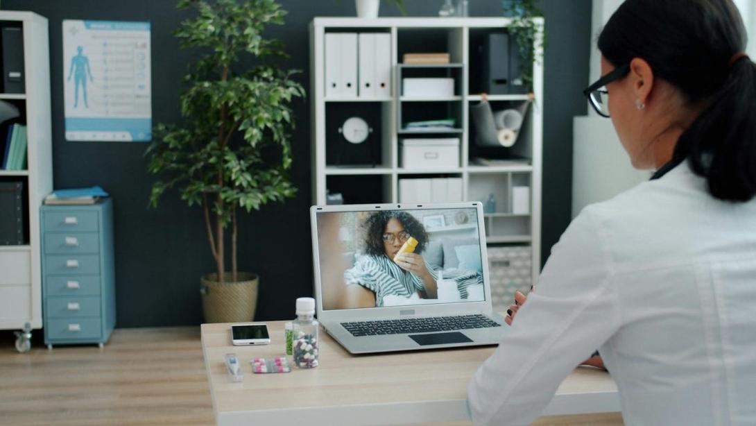 Arzt berät eine Patientin per Videoanruf am Laptop
